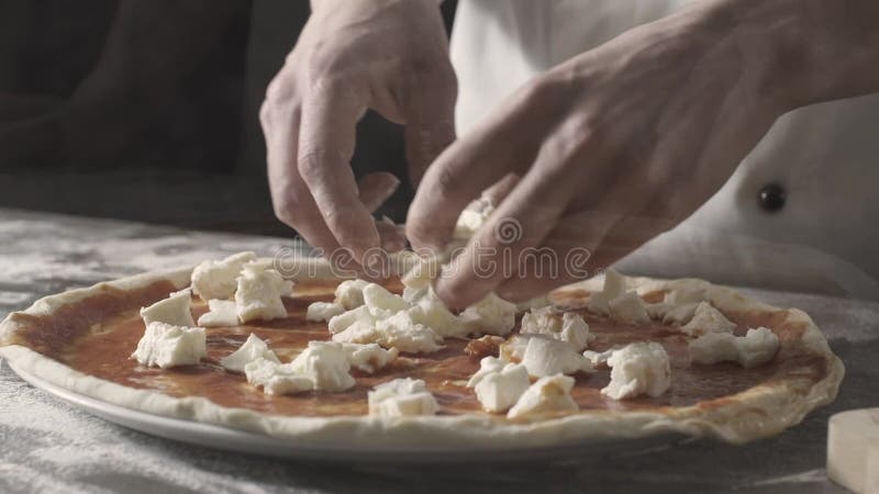 Professionell kock som bereder en fin färsk pizza