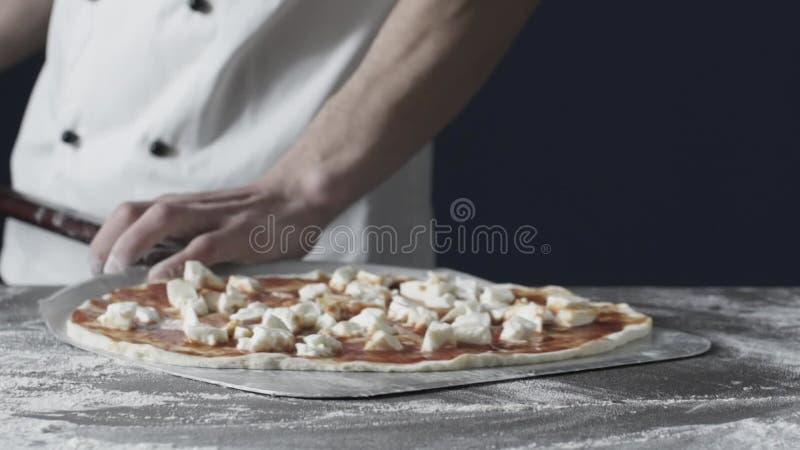 Professionell kock som bereder en fin färsk pizza