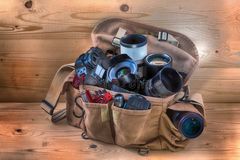 Professionelle photographische Tasche für Reporter, voll von der Kamera, von den Linsen und von anderen nützlichen Einzelteilen f stockbild Professionelle photographische Tasche für Reporter, voll von der Kamera, von den Linsen und von anderen nützlichen Einzelteilen f stockbild