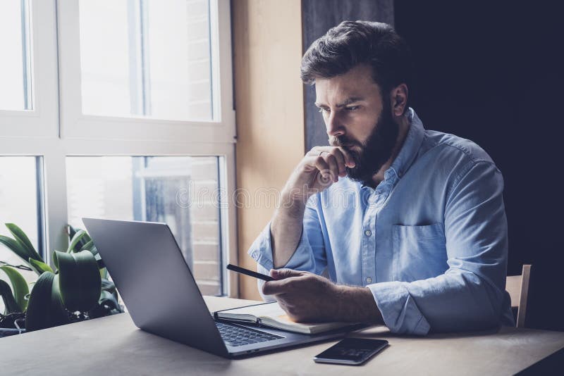 Professionellt sittande på kontoret framför den bärbara datorn Hemmabaserad student som får distansutbildning En seriös person so fotografering för bildbyråer