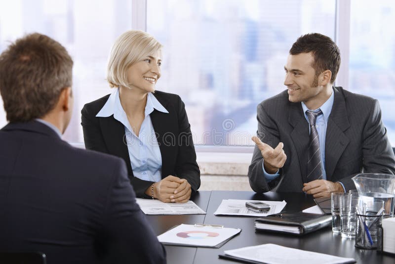 Professionisti sorridenti in ufficio immagine stock Professionisti sorridenti in ufficio immagine stock