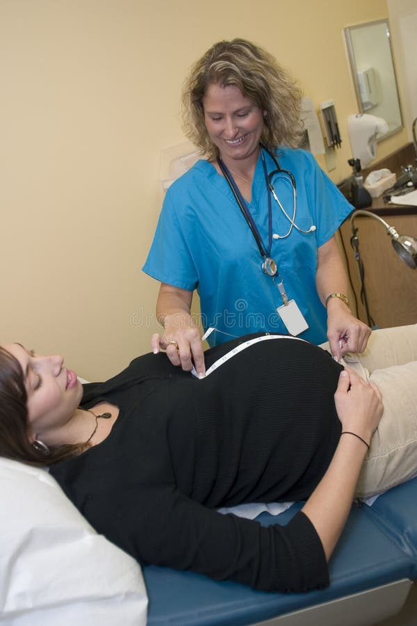 Professionnel médical féminin avec mesurer le femme enceinte images libres de droits Professionnel médical féminin avec mesurer le femme enceinte images libres de droits
