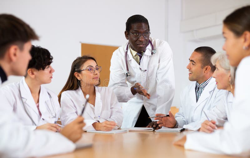 Professor afro-americano de medicina dando palestra a grupos de médicos estagiários fotografia de stock