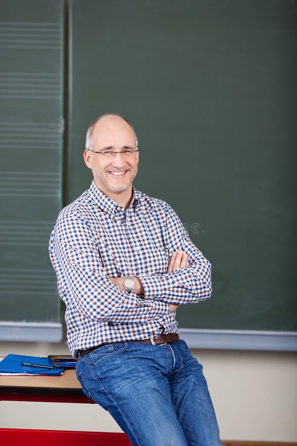 Professor With Arms Crossed Sitting On Desk stock photos