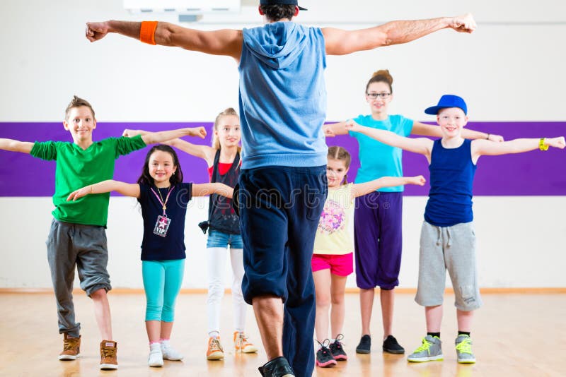 Professor da dança que dá a crianças a classe da aptidão de Zumba fotografia de stock Professor da dança que dá a crianças a classe da aptidão de Zumba fotografia de stock