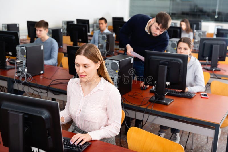 Diligent teacher conducts computer science exam in university class. Diligent teacher conducts computer science exam in university class