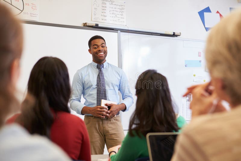 Professor masculino na frente dos estudantes em uma classe do ensino para adultos