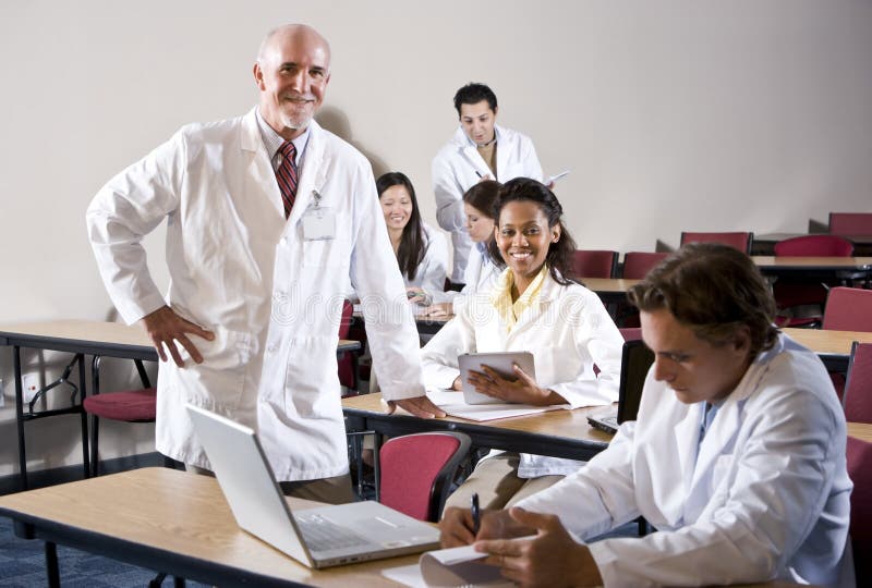 Médico estudiantes agotador laboratorio abrigos en la clase.