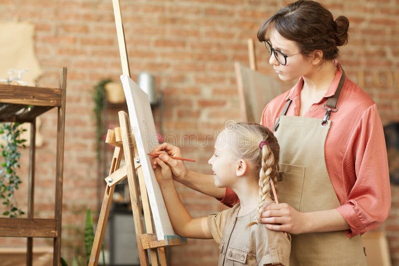 Jovem Professora Ensina Crianças a Pintar Imagens Sorrindo