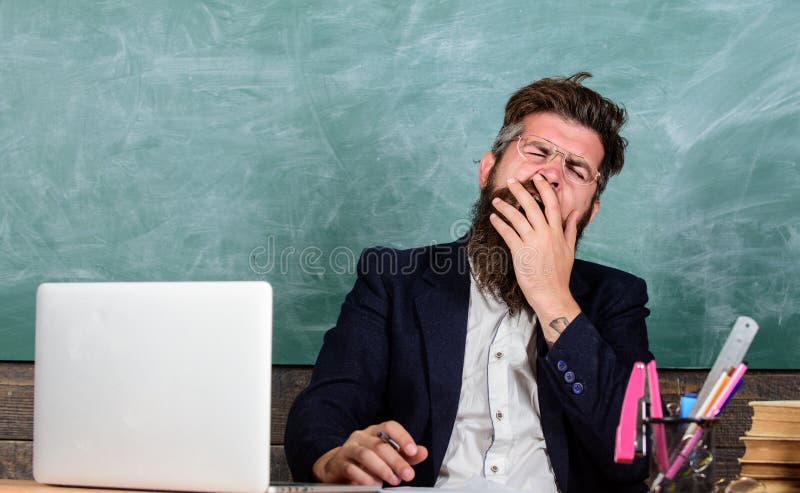 Professores forçados mais no trabalho do que os povos médios Fadiga de nível elevado Cara de bocejo do homem farpado do professor fotografia de stock Professores forçados mais no trabalho do que os povos médios Fadiga de nível elevado Cara de bocejo do homem farpado do professor fotografia de stock