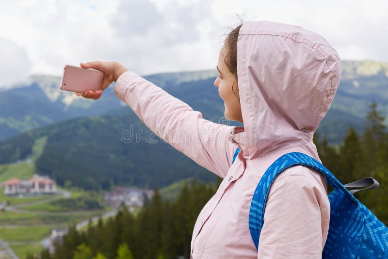 Profil des aktiven Reisenden Foto auf Gebirgshintergrund, notierendes Video machend für Reiseblog, Zeit mit Vergnügen an verbring stockfotografie Profil des aktiven Reisenden Foto auf Gebirgshintergrund, notierendes Video machend für Reiseblog, Zeit mit Vergnügen an verbring stockfotografie