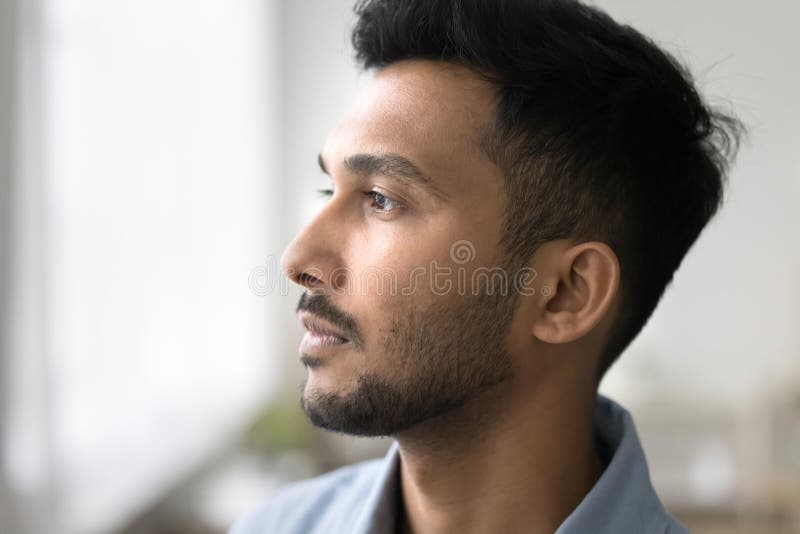Profil eines pensionierten jungen Mannes, der vor dem Fenster steht stockbilder