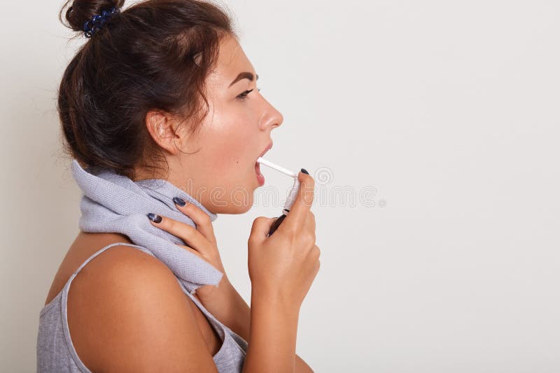 Profil portret atrakcyjnej brunetki młoda kobieta z bliznami wokół szyi, wykorzystuje spray do leczenia bólu gardła, chore samice obrazy royalty free Profil portret atrakcyjnej brunetki młoda kobieta z bliznami wokół szyi, wykorzystuje spray do leczenia bólu gardła, chore samice obrazy royalty free