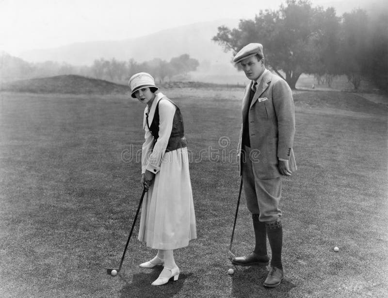 Profile of a couple playing golf in a golf course