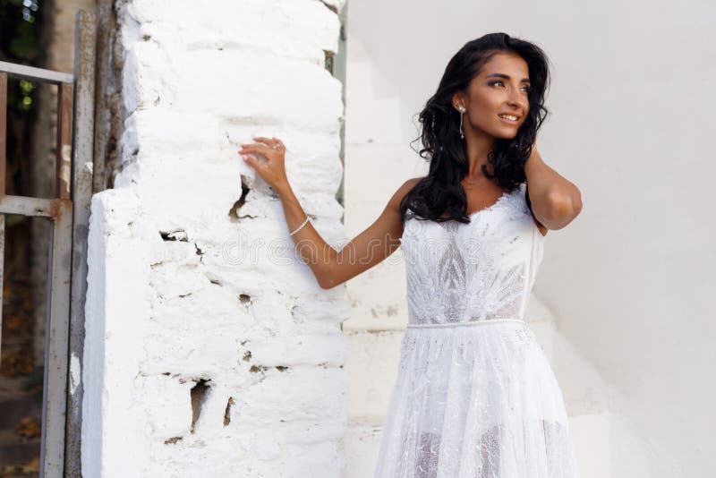 Beautiful bride In a white dress posing against the backdrop of the city of  Thira, Santorini. 6919168 Stock Photo at Vecteezy