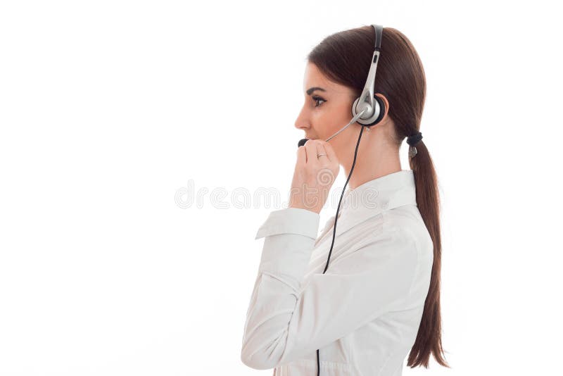 Profile portrait of pretty young brunette call office worker woman with headphones and microphone isolated on white royalty free stock photography Profile portrait of pretty young brunette call office worker woman with headphones and microphone isolated on white royalty free stock photography