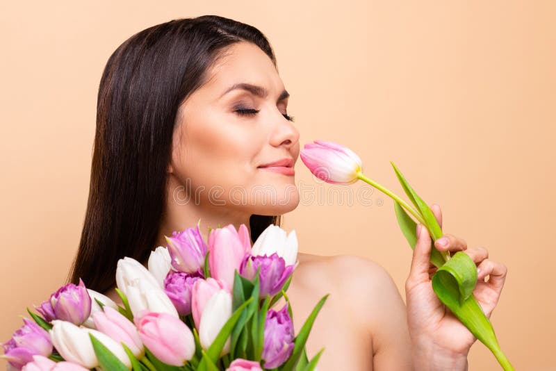 Profile side photo of happy nice young woman smell flower tulip healthcare  on pastel beige color background