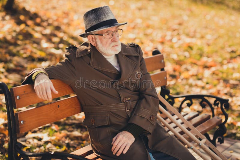 Profile side photo of lonely old man have no friend family sit bench in fall town park with wooden crutch wear season