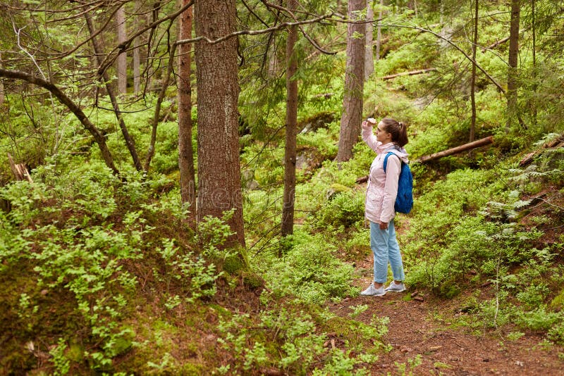Profile of sporty active young female with pony tail wearing light pink jacket, blue backback, jeans and sneakers, standing in royalty free stock photos Profile of sporty active young female with pony tail wearing light pink jacket, blue backback, jeans and sneakers, standing in royalty free stock photos