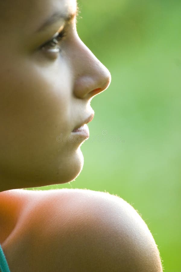 A closeup, over-the-shoulder profile view of a pretty teenage girl. A closeup, over-the-shoulder profile view of a pretty teenage girl.