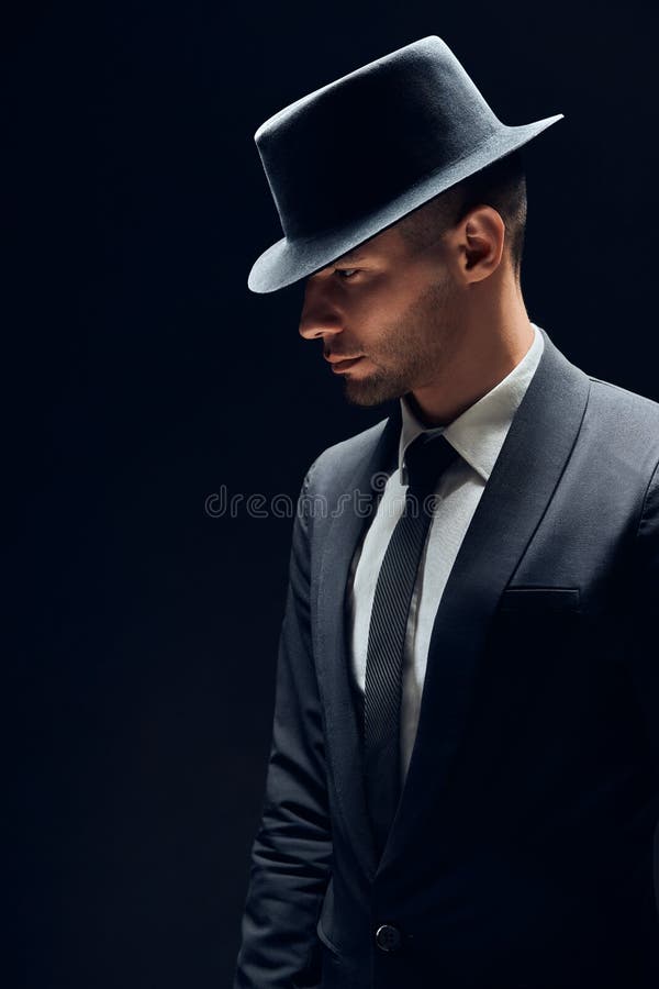 Profile view portrait oh handsome man in black suit and hat on dark background stock images Profile view portrait oh handsome man in black suit and hat on dark background stock images