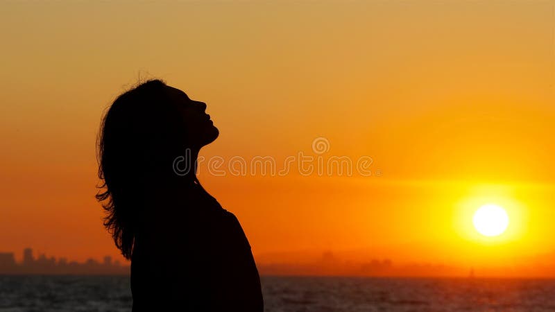 Profile of a woman breathing fresh air at sunset