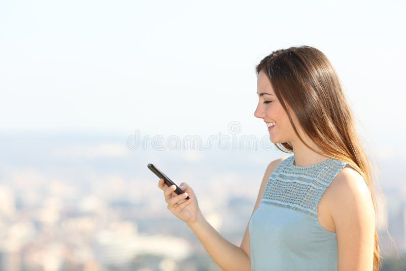 Profile of a woman using smartphone in the city outskirts stock photography Profile of a woman using smartphone in the city outskirts stock photography