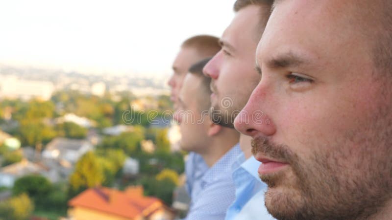 Profilo di giovani imprenditori che guardano panorama della città dal terrazzo dell'edificio Highrise. volti di fiducia