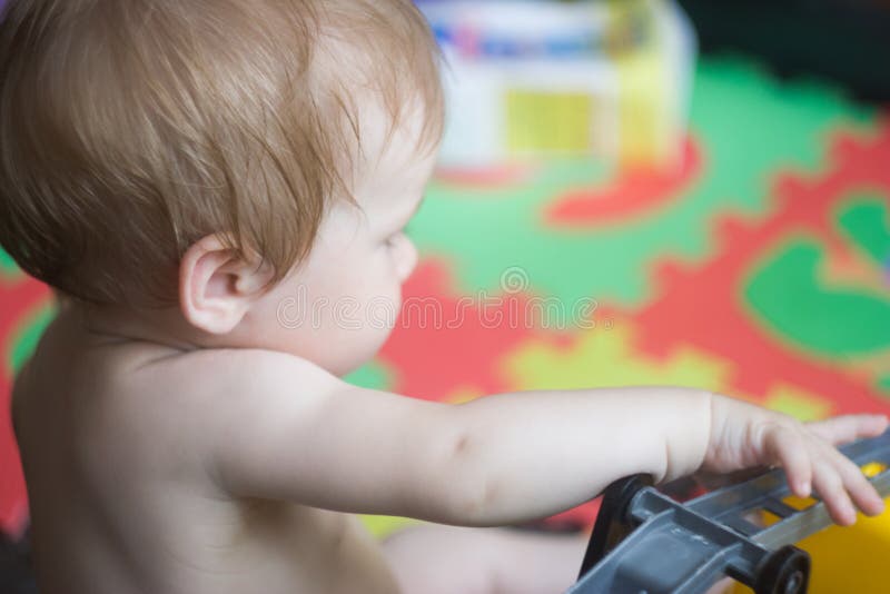 Profilo di una bambina che gioca in una stanza del ` s dei bambini immagine stock libera da diritti Profilo di una bambina che gioca in una stanza del ` s dei bambini immagine stock libera da diritti