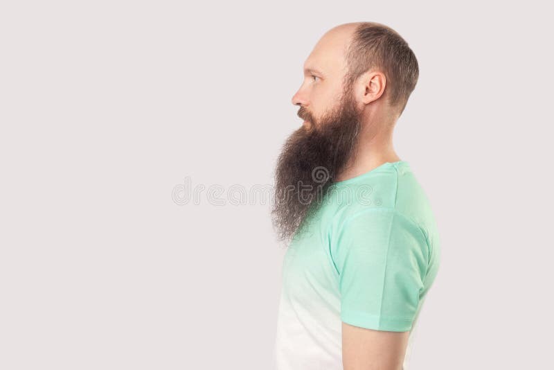 Profilseitenansicht Portrait von ruhiger entspannter Mittelalter Glatze Mann mit langem Bart in hellgrünem T-Shirt stehen und aus