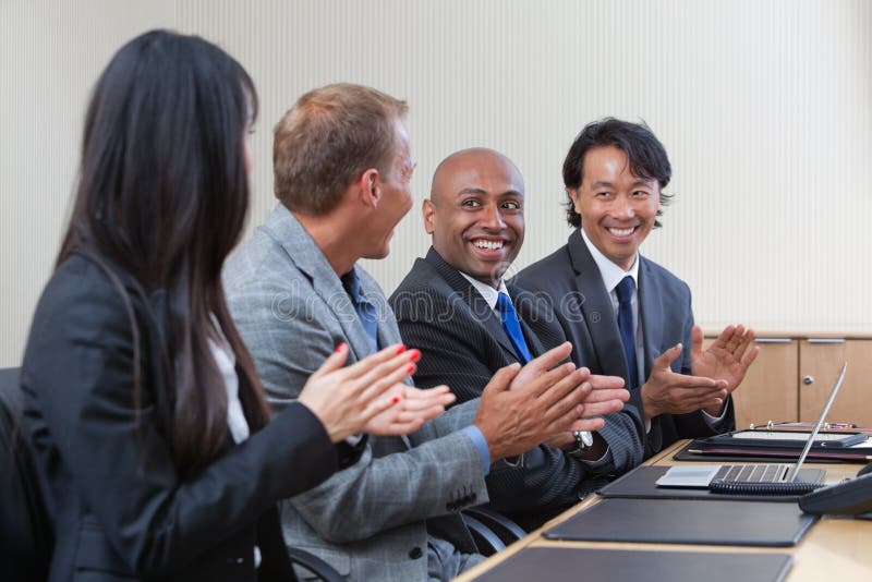 Profissionais que aplaudem durante uma reunião de negócio