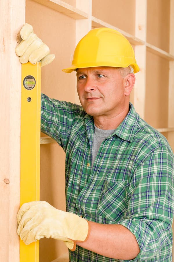 Handyman mature professional with spirit level working on home renovations. Handyman mature professional with spirit level working on home renovations