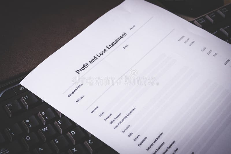 Profit and Loss Statement on Black Keyboard and Brown Leather Notebook on Pine Desk stock image