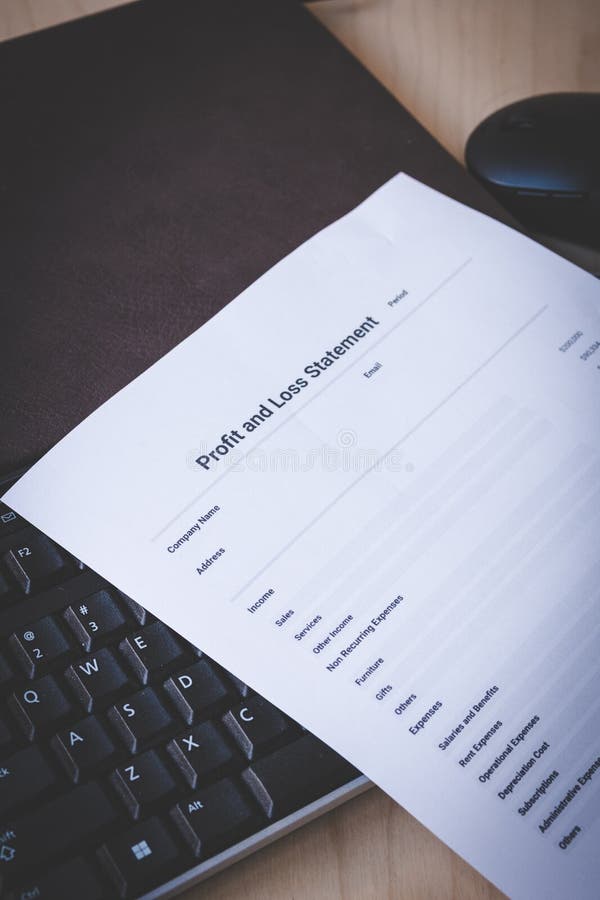 Profit and Loss Statement on Black Keyboard and Brown Leather Notebook on Pine Desk royalty free stock photography