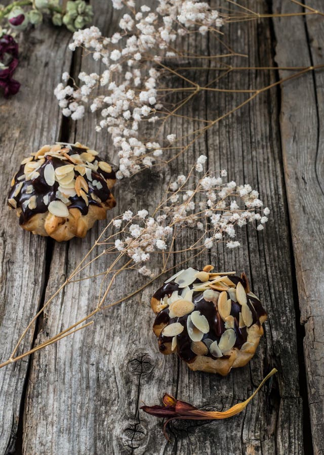 Profiteroles застеклило в шоколаде и взбрызнутый с shavings грецкого ореха Деревянная предпосылка Конец-вверх стоковая фотография Profiteroles застеклило в шоколаде и взбрызнутый с shavings грецкого ореха Деревянная предпосылка Конец-вверх стоковая фотография