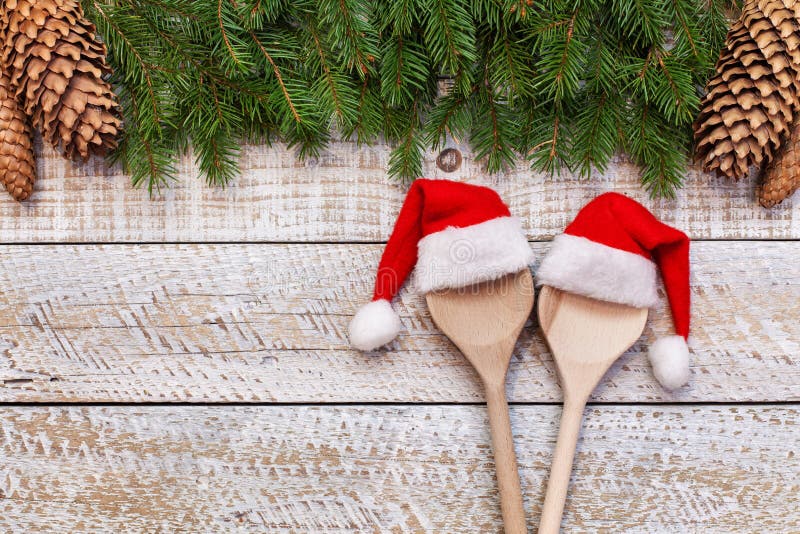 Progettando il menu di natale - due cucchiai di legno con i cappelli di Santa immagine stock Progettando il menu di natale - due cucchiai di legno con i cappelli di Santa immagine stock