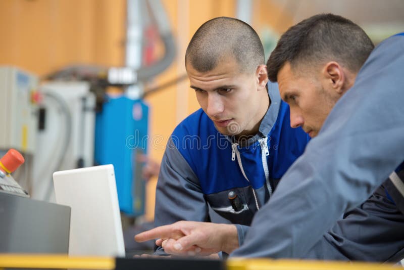 Progettista di legno due che lavora con il computer portatile in officina fotografia stock libera da diritti Progettista di legno due che lavora con il computer portatile in officina fotografia stock libera da diritti
