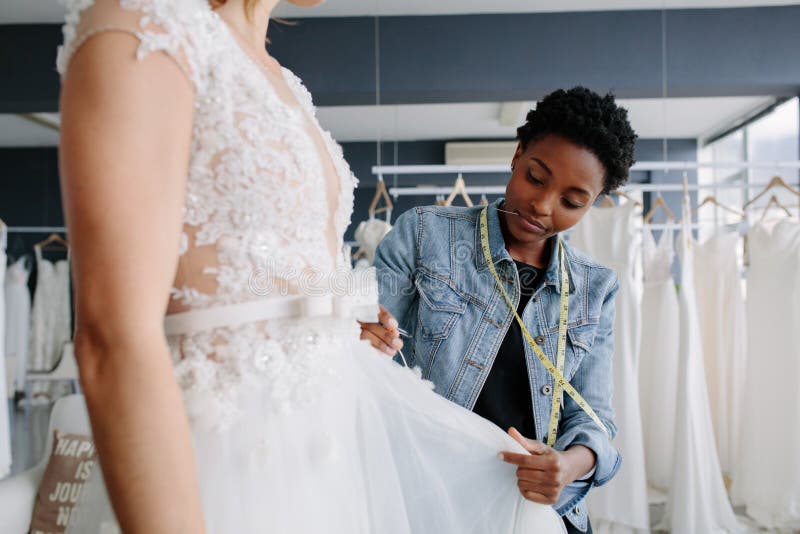 Progettista professionista del vestito da sposa che misura abito nuziale alla donna