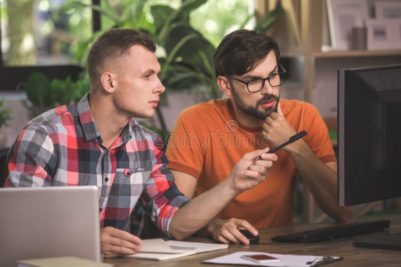 Programadores de los hombres jovenes que trabajan junto en la oficina foto de archivo libre de regalías Programadores de los hombres jovenes que trabajan junto en la oficina foto de archivo libre de regalías