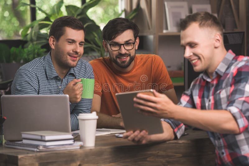Programadores dos homens novos que trabalham junto no escritório imagens de stock Programadores dos homens novos que trabalham junto no escritório imagens de stock