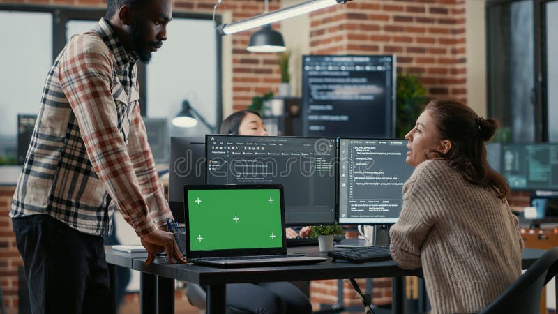 Programer working at desk with multiple computer screens and laptop with green screen chroma key mockup royalty free stock photos