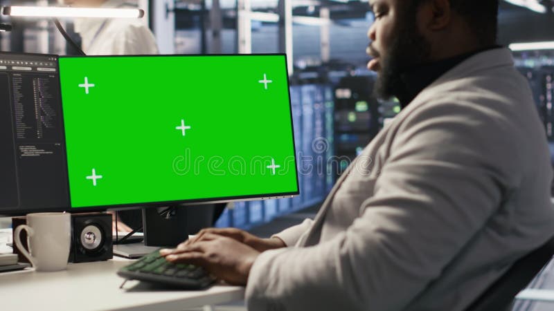 Programmateur de datacenter travaillant sur PC de bureau à écran vert banque de vidéos