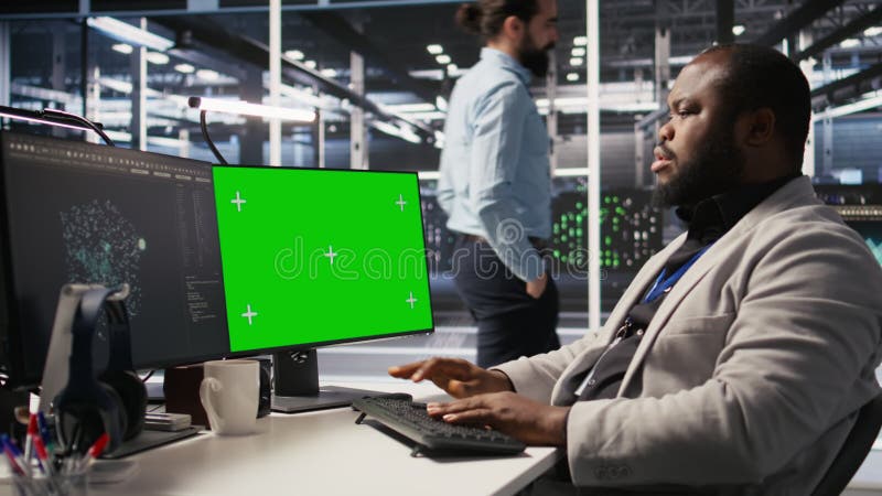 Programmateur de datacenter travaillant sur PC de bureau à écran vert banque de vidéos