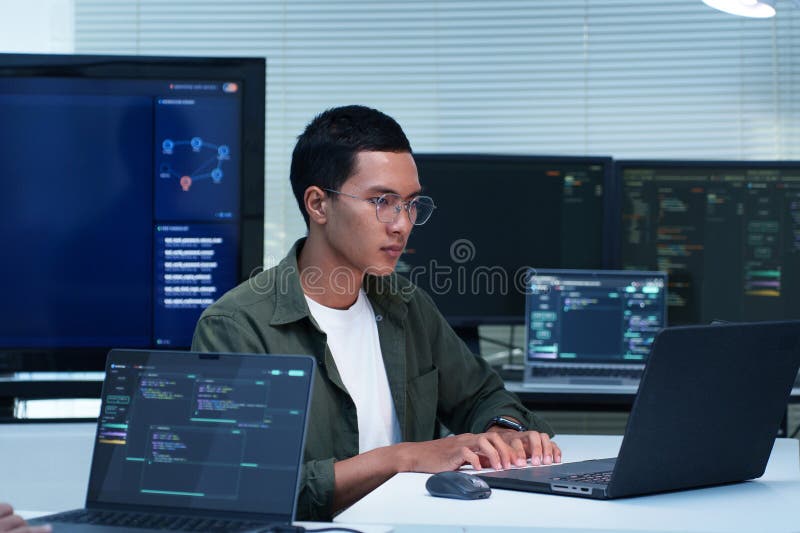 Programmer developing software code with multiple computer screens software developer programming artificial intelligence стоковое изображение