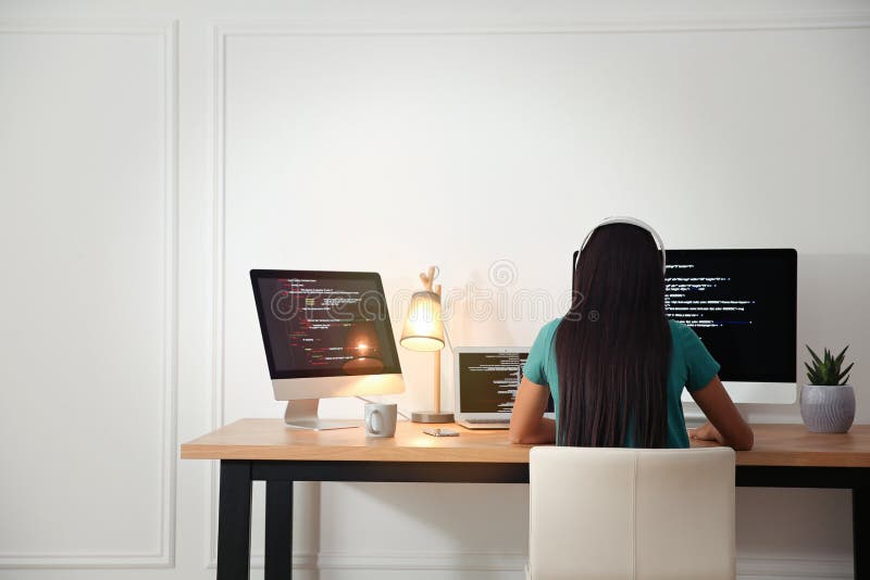 Programmer with headphones working at desk stock image