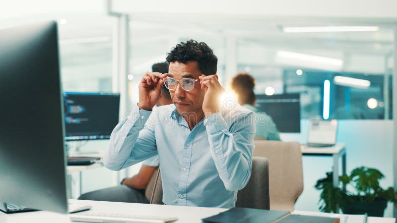 Programmer, research or man with glasses in office for reading code, app development and debugging. Computer stock image