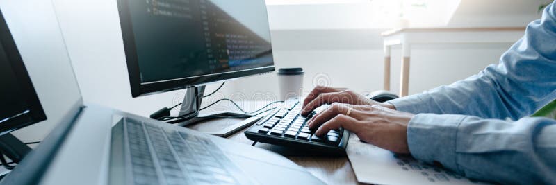 Programmer working On Computer In IT Office Typing Data Coding in software and checking code on computer screen stock photos