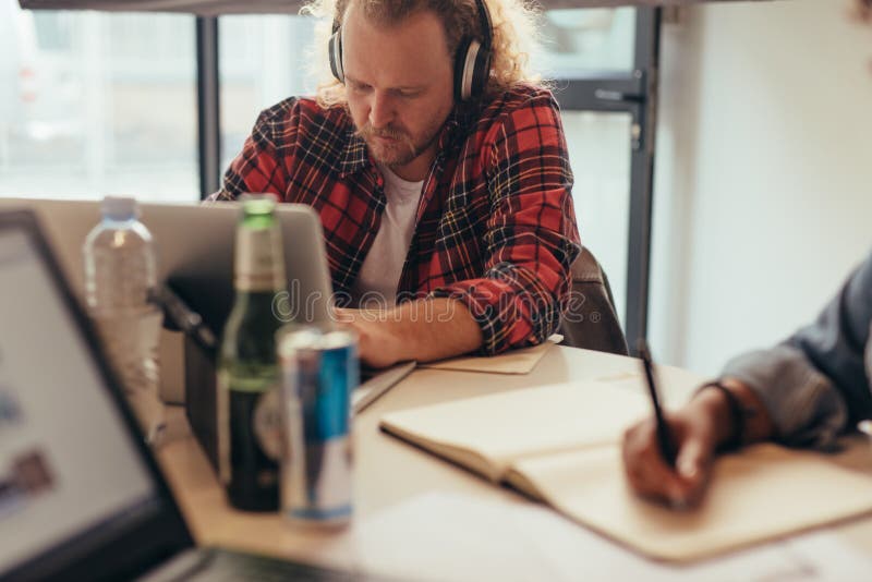 Programmer working on laptop at startup company stock photo