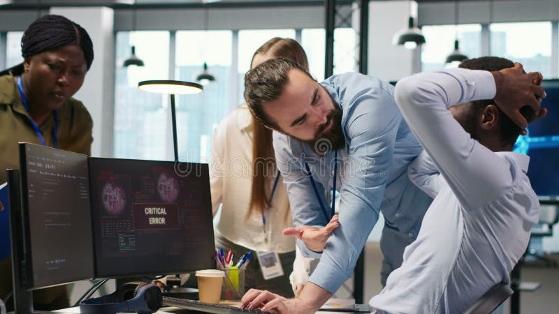 Programmerare på kontoret som begär hjälp från medarbetare för att åtgärda ett kritiskt fel lager videofilmer