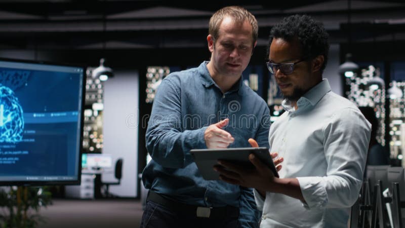 Programmers in office analyzing machine learning algorithms to prevent AI model errors. Colleagues reviewing code logic to improve artificial intelligence prediction accuracy, camera B. Expert application video